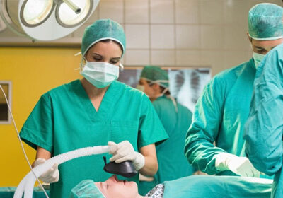 A group of doctors in green scrubs and masks.